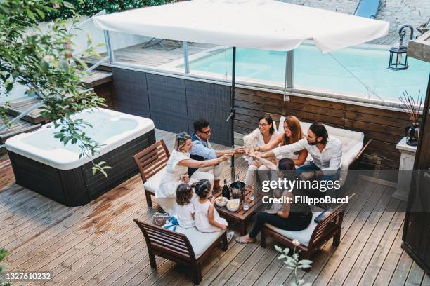 friends are toasting together near a swimming pool - girls in hot tub stockfoto's en -beelden