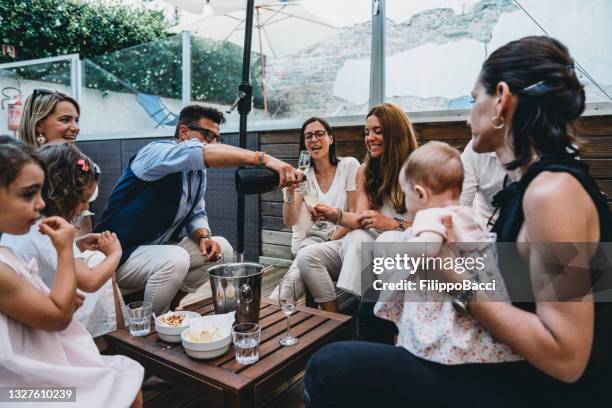 friends are celebrating together with a bottle of champagne - aperitief stockfoto's en -beelden