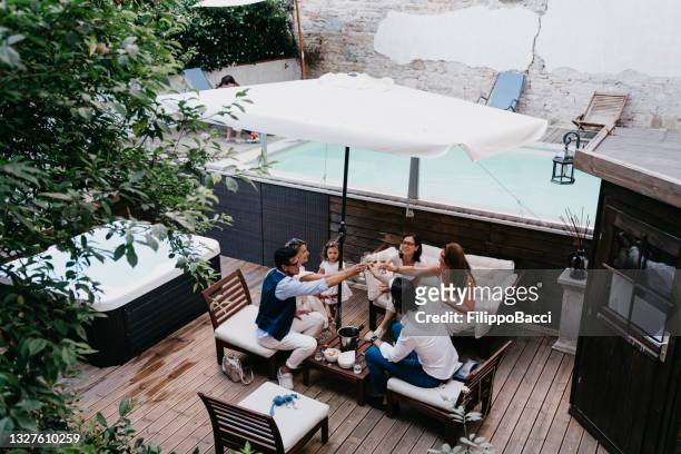 friends are toasting together near a swimming pool - girls in hot tub stockfoto's en -beelden