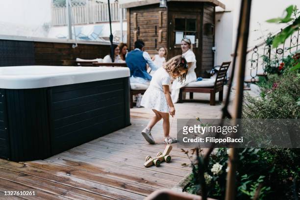 una niña está jugando con un tren de madera en un complejo turístico - girls in hot tub fotografías e imágenes de stock