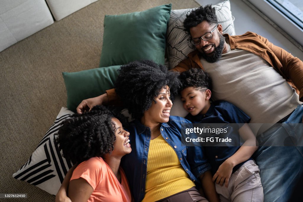 Famiglia felice insieme sdraiata a terra a casa