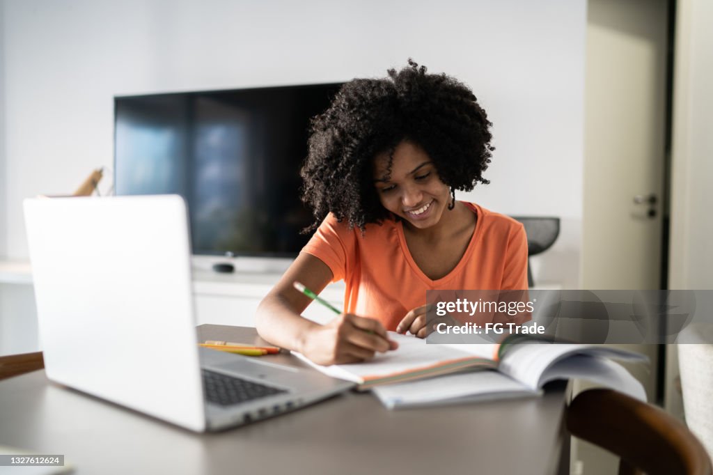 Adolescente estudando em casa