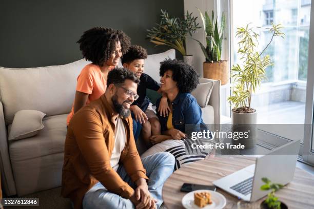 familie, die einen videoanruf macht oder etwas auf dem laptop zu hause ansieht - daily life in brazil stock-fotos und bilder