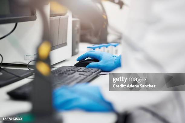 aufnahme eines wissenschaftlers mit einem computer bei der medizinischen forschung in einem labor - scientist standing next to table stock-fotos und bilder