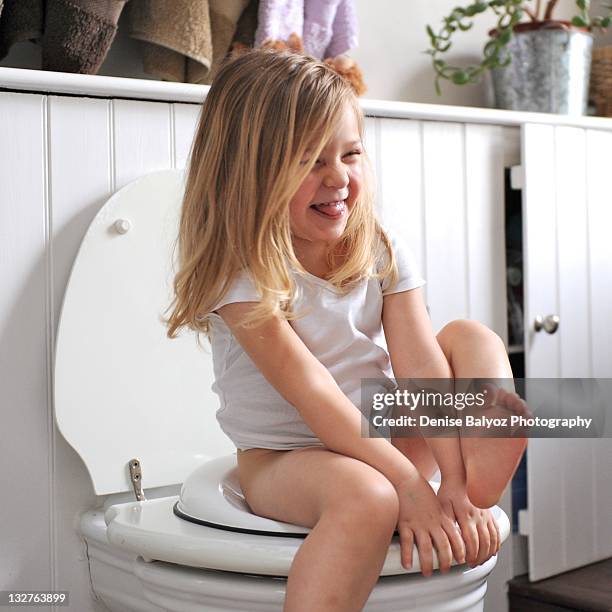 girl laughs while sitting on loo - childrens closet stockfoto's en -beelden