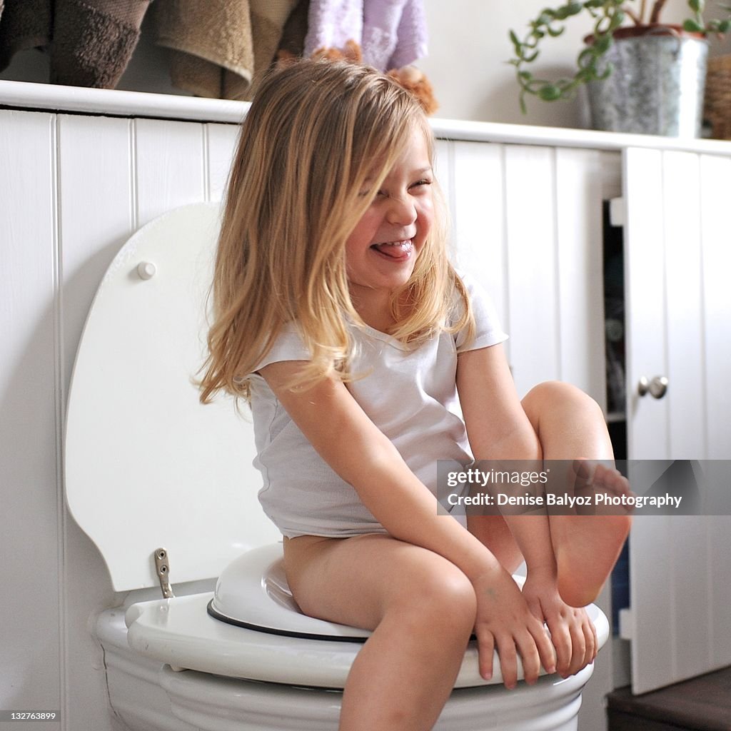 Girl laughs while sitting on loo