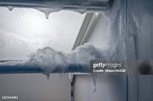 frost and ice on the inside shelf of a freezer in a domestic kitchen - freezer stock pictures, royalty-free photos & images