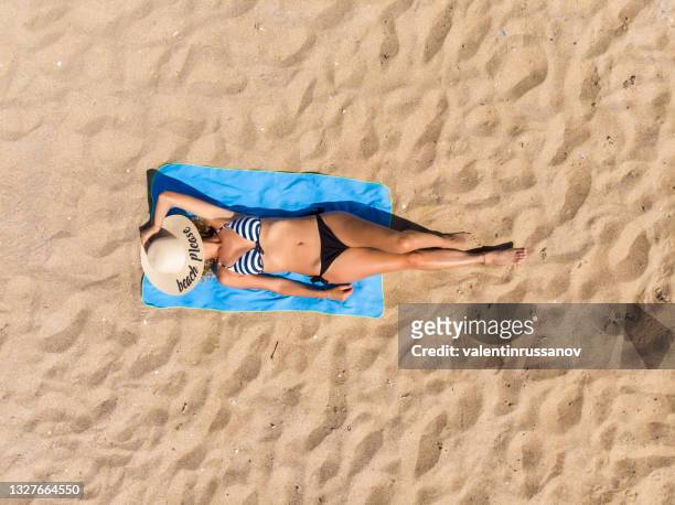 woman lying on the beach - woman towel beach stockfoto's en -beelden