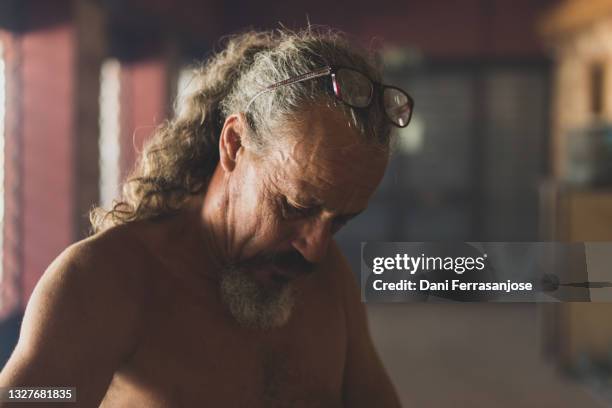 portrait of middle-aged man with wrinkles and gray hair looking down - ruffled hair stock pictures, royalty-free photos & images