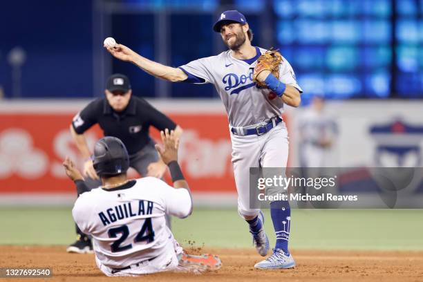 Chris Taylor of the Los Angeles Dodgers attempts to turn a double play past a sliding Jesus Aguilar of the Miami Marlins during the eighth inning at...