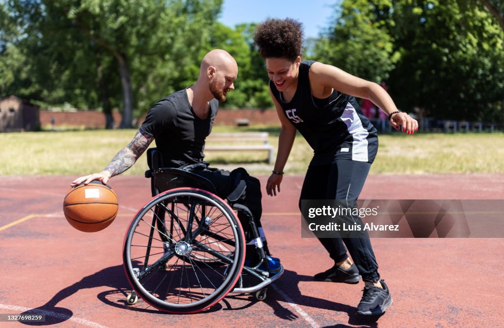 Wheelchair basketball player improving his game skills with coach