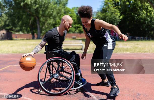 wheelchair basketball player improving his game skills with coach - basketball sport stock-fotos und bilder