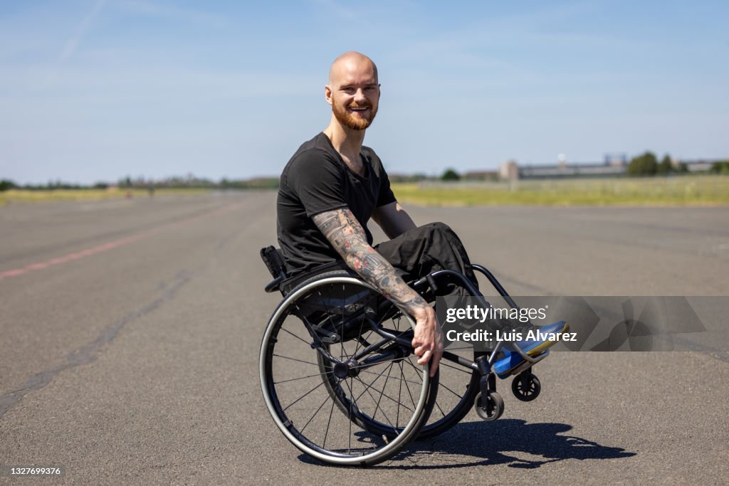 Portrait of man with disability on wheelchair doing a wheelie