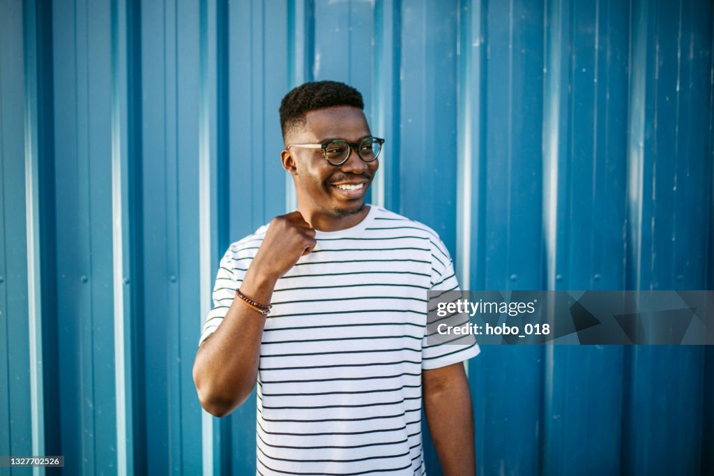 Young, cheerful black man on blue door background