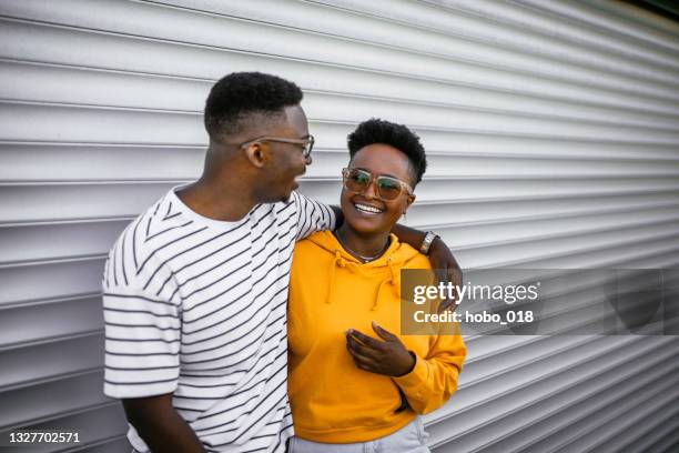 cheerful heterosexual couple in a front of white garage door - all hip hop models stock pictures, royalty-free photos & images