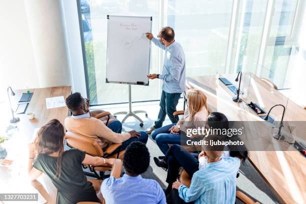 selbstbewusster business trainer coach gibt flipchart-präsentation - staff benefits corporate stock-fotos und bilder