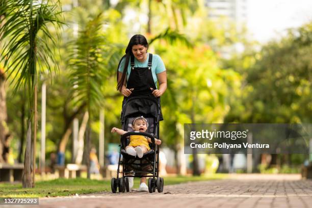 mutter geht tochter kinderwagen im freien - baby pram in the park stock-fotos und bilder