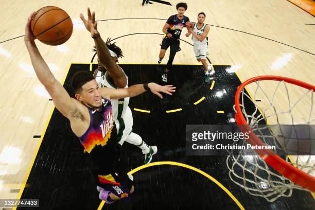 Devin Booker of the Phoenix Suns goes up for a slam dunk ahead of Jrue Holiday of the Milwaukee Bucks in the first half of game two of the NBA Finals...