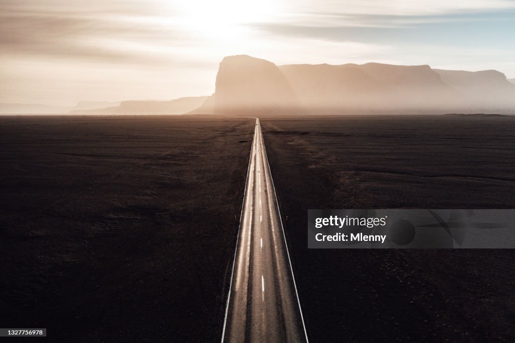 Endlose gerade Straße in die Sonne auf Island
