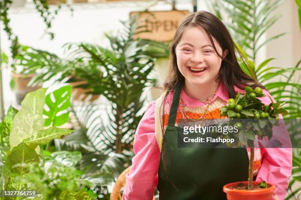 portrait of happy, confident florist in flower shop laughing - persons with disabilities stock-fotos und bilder