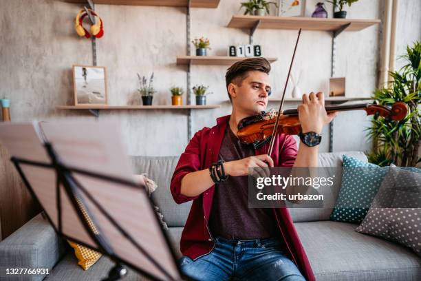 young violinist practicing playing at home - classical musician stock pictures, royalty-free photos & images