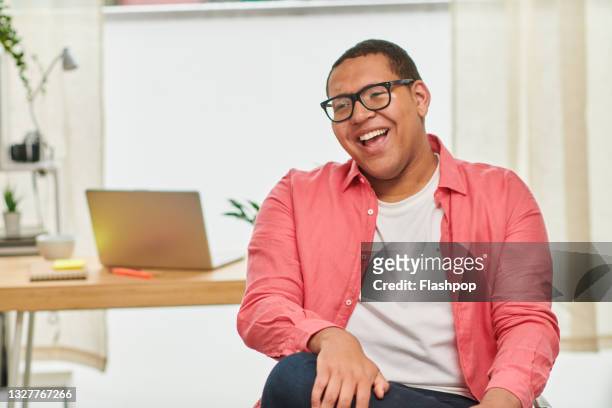 portrait of happy, confident young man in office laughing - individuality male stock pictures, royalty-free photos & images