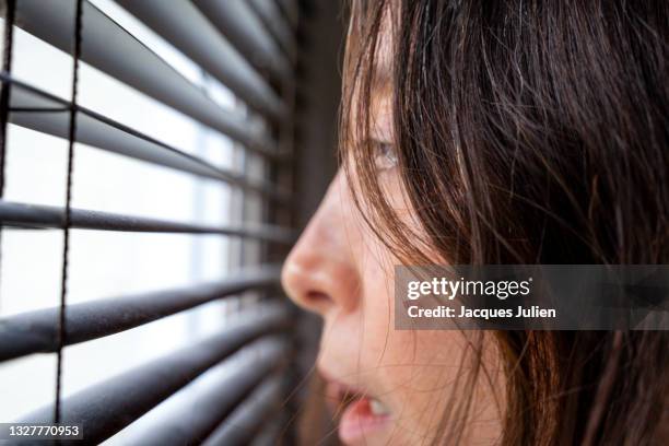 scared woman at the window - paris attack stock-fotos und bilder