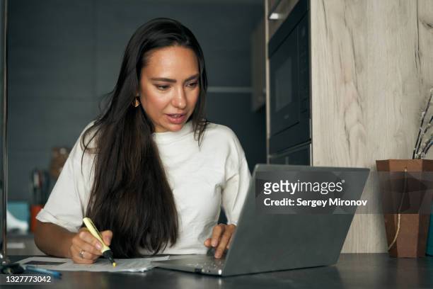 woman working on laptop at home - income taxes stock pictures, royalty-free photos & images