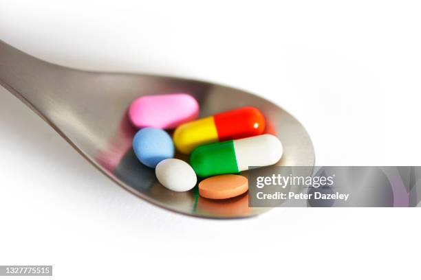close up of selection of pills on spoon - prescription drugs dangers stock pictures, royalty-free photos & images