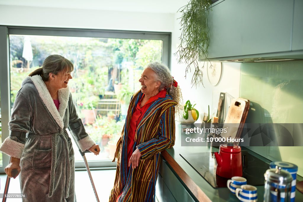 Two flatmates laughing and smiling in kitchen