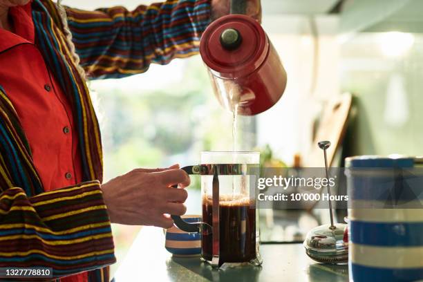 close up of senior woman pouring boiling water into a cafetiere - café preto imagens e fotografias de stock