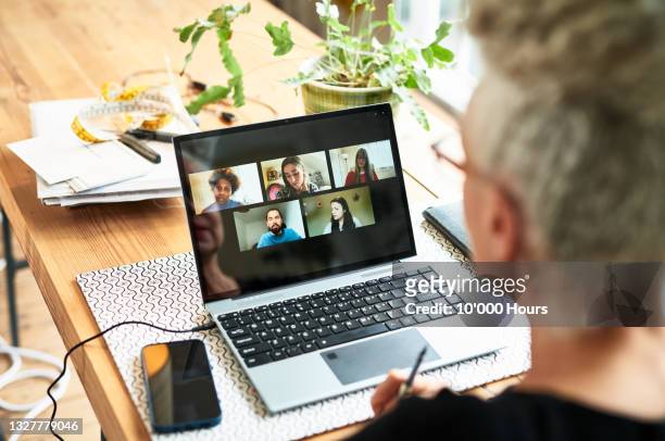 senior businesswoman using laptop for team meeting video conference - talking close up business stockfoto's en -beelden
