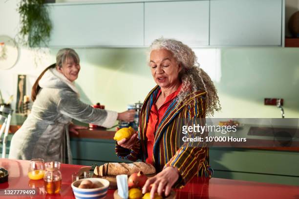 two flatmates in kitchen preparing breakfast - roommate fotografías e imágenes de stock