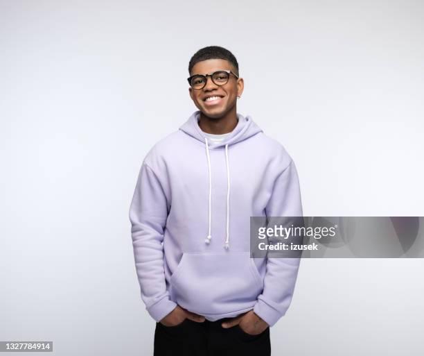 cheerful young man wearing lilac hoodie - white backdrop stock pictures, royalty-free photos & images