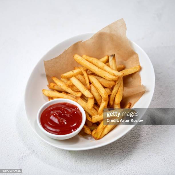 fried potatoes with tomato sauce, fries with ketchup. food plate isolated on white background - french fries white background stock-fotos und bilder