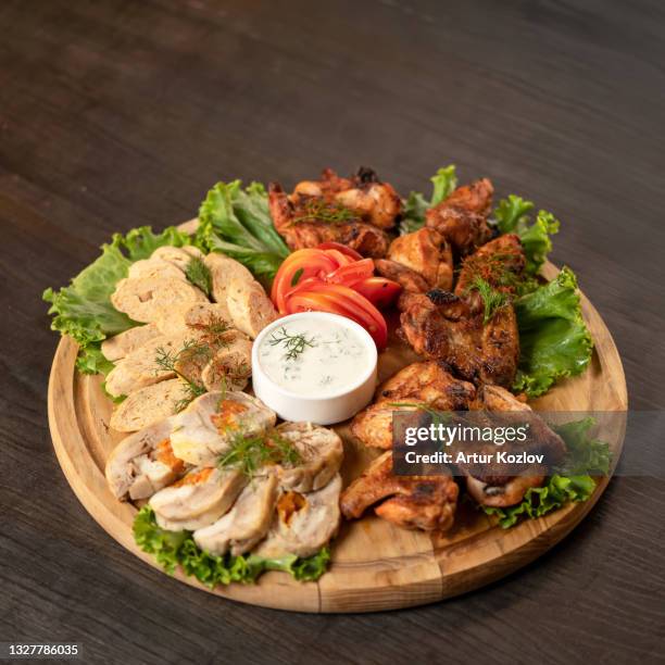 meat appetizer. pieces of baked meat and friesh lettuce leaves on wooden cutting board with mayonnaise sauce in center of it. copy space. soft focus - buffalo chicken lettuce stock pictures, royalty-free photos & images