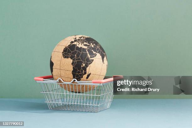 a world globe in a shopping basket - duurzaam consumeren stockfoto's en -beelden
