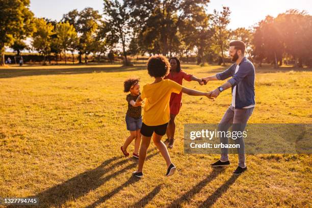 família feliz jogando anel em torno do rosado - brincadeira de roda - fotografias e filmes do acervo
