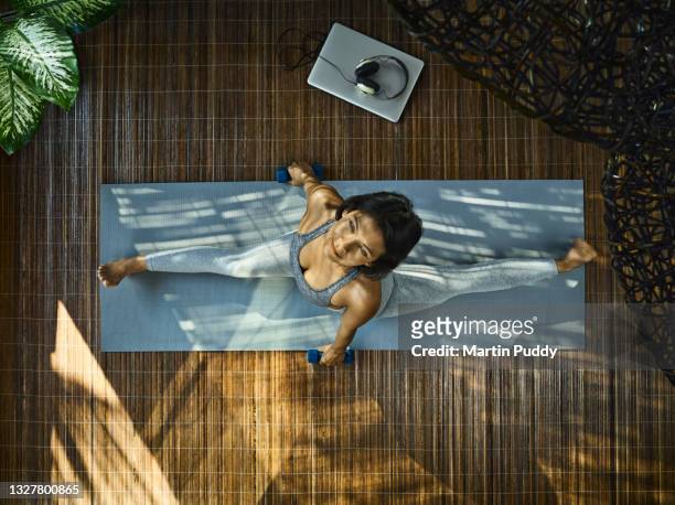 asian woman practicing yoga, using dumbbells during home workout in living room, aerial view - asian female bodybuilder 個照片及圖片檔
