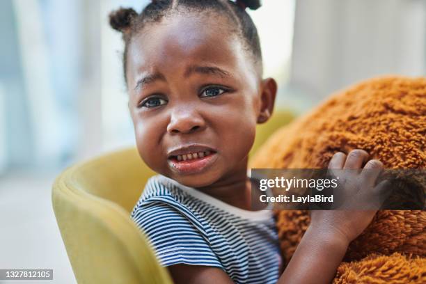 shot of a cute little girl crying while sitting in the waiting room of a doctor’s office - sad child hospital stock pictures, royalty-free photos & images