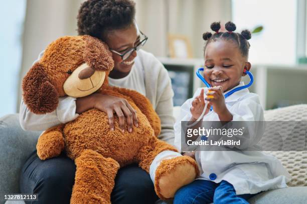 plan d’une adorable petite fille et de sa mère jouant avec un stéthoscope dans la salle d’attente du cabinet d’un médecin - ours en peluche photos et images de collection