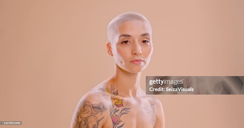Studio shot of a beautiful young woman standing against a peach background