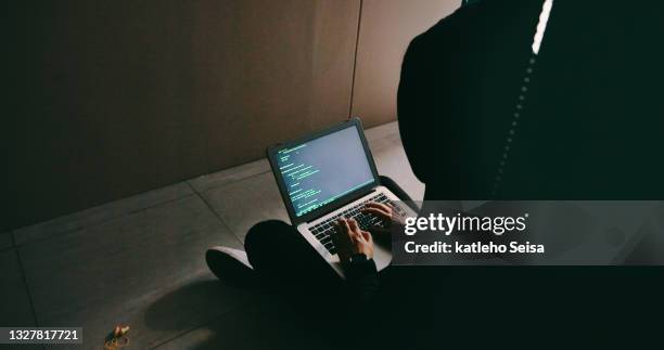 foto de un joven hacker usando una computadora portátil en una sala de servidores - software antivirus fotografías e imágenes de stock