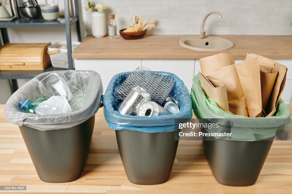 Row of three trash bins with sorted garbage