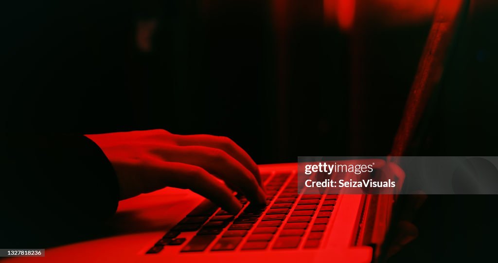 Shot of a hacker using a laptop