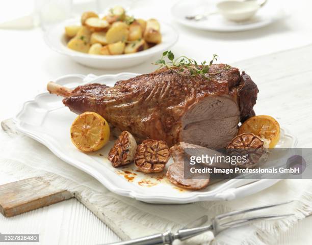 roast leg of lamb with garlic and lemons - leg of lamb stock pictures, royalty-free photos & images