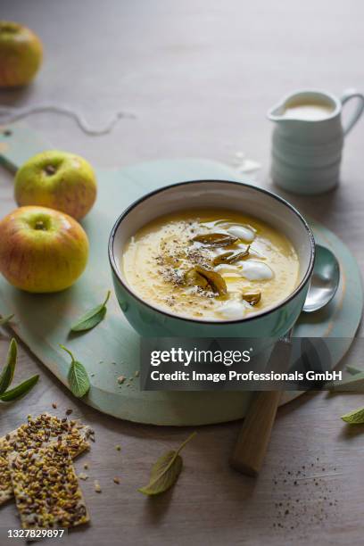 a bowl of celeriac and apple soup with sage and crackers - celeriac stockfoto's en -beelden