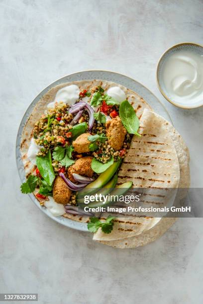 wrap with tabbouleh and falafels, greek yoghurt, avocado, spinach and coriander - faláfel fotografías e imágenes de stock