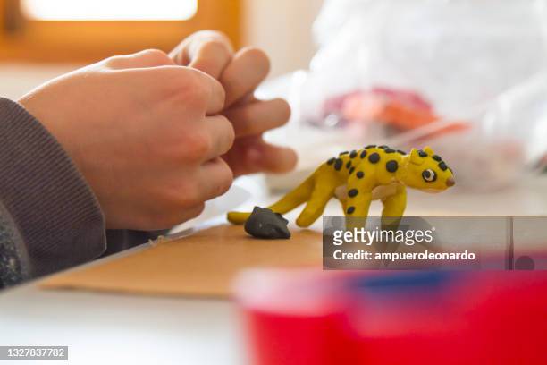 child moulds from plasticine on table. - klei stockfoto's en -beelden