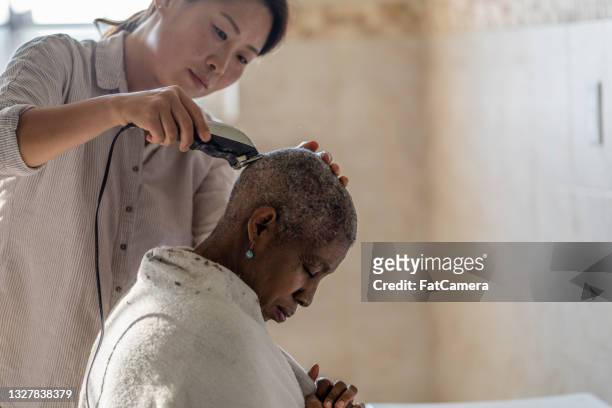 cancer patient gets her head shaved - hairdressers black woman stockfoto's en -beelden